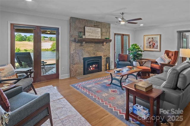 living room featuring ceiling fan, crown molding, a fireplace, recessed lighting, and wood finished floors