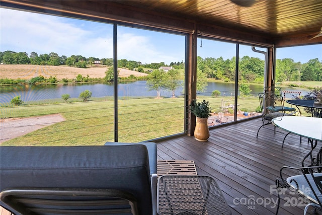 sunroom featuring a water view and view of scattered trees