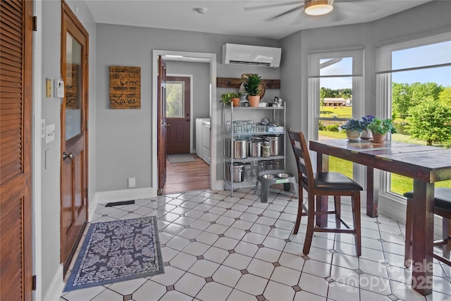 dining space with a wall mounted air conditioner, ceiling fan, plenty of natural light, and independent washer and dryer