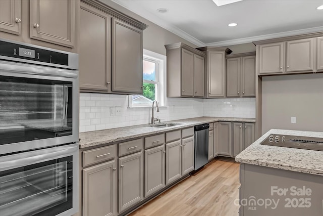 332 E Rebound Rd, Lancaster, SC 29720 - kitchen with stainless steel appliances, a sink, gray cabinets, light wood-style flooring, and light stone counters
