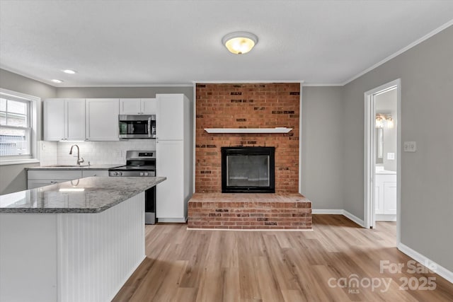 332 E Rebound Rd, Lancaster, SC 29720 - kitchen with appliances with stainless steel finishes, a sink, light wood-style flooring, light stone counters, and white cabinets