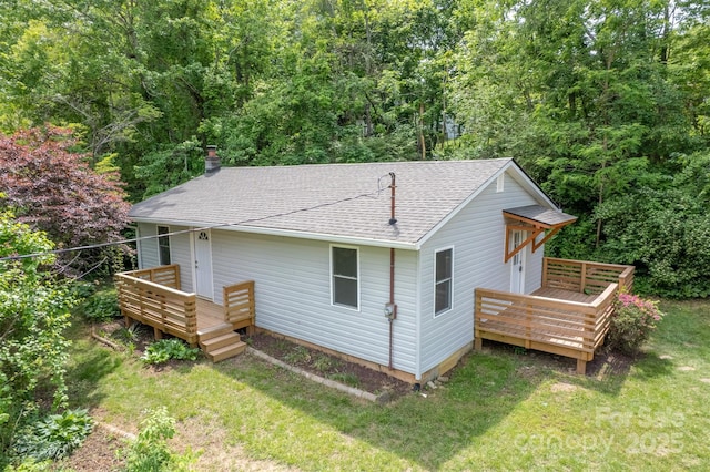 307 Hawthorne Ave, Swannanoa, NC 28778 - view of property exterior featuring a shingled roof, a wooden deck, a yard, and a chimney