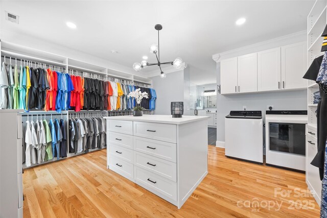 184 Quiet Cove Rd, Mooresville, NC 28117 - spacious closet featuring a chandelier, light wood-style floors, and separate washer and dryer