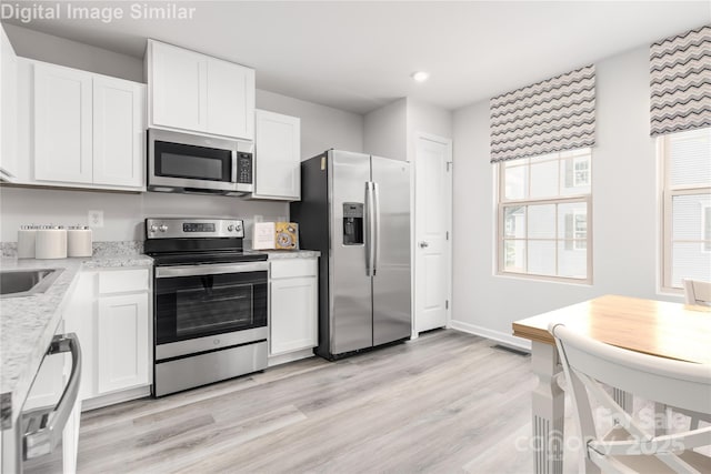 1430 Samuel St, Charlotte, NC 28206 - kitchen with stainless steel appliances, white cabinetry, light wood-style floors, baseboards, and recessed lighting