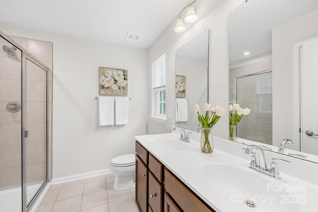 2012 Slippery Rock Ln, Monroe, NC 28112 - full bath with double vanity, a shower stall, tile patterned flooring, baseboards, and toilet