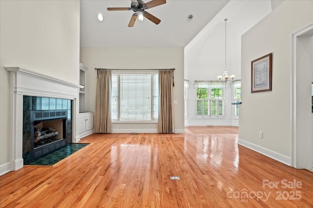 600 Robinhood Dr, Cheraw, SC 29520 - unfurnished living room with ceiling fan with notable chandelier, high vaulted ceiling, a fireplace, light wood-type flooring, and baseboards