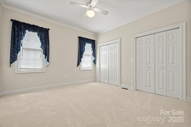 600 Robinhood Dr, Cheraw, SC 29520 - unfurnished bedroom with carpet floors, two closets, visible vents, baseboards, and ornamental molding