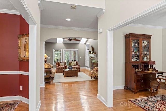 216 Cold Stream Way, Hendersonville, NC 28791 - entrance foyer featuring a ceiling fan, light wood-style flooring, crown molding, arched walkways, and a fireplace