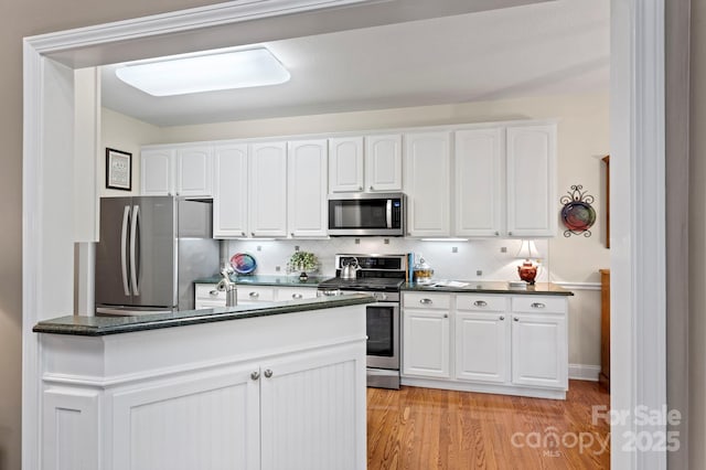 216 Cold Stream Way, Hendersonville, NC 28791 - kitchen with white cabinetry, light wood finished floors, dark countertops, and stainless steel appliances