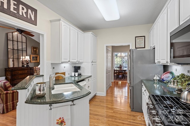 216 Cold Stream Way, Hendersonville, NC 28791 - kitchen with a peninsula, light wood-style flooring, a sink, white cabinetry, and stainless steel microwave