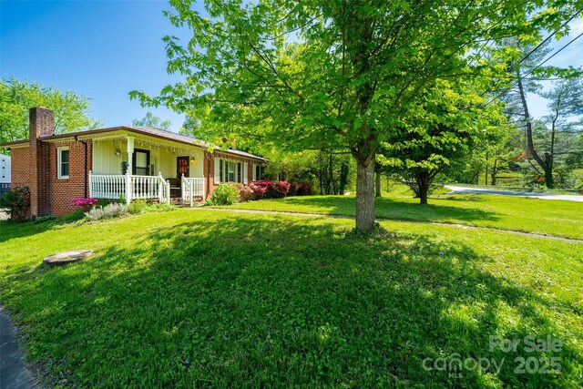 view of grassy yard with covered porch