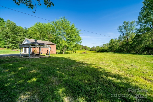view of grassy yard featuring a gazebo and a patio area