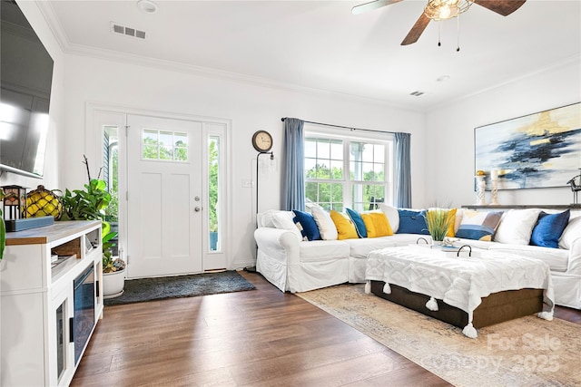 living area with crown molding, a ceiling fan, and dark wood-style flooring
