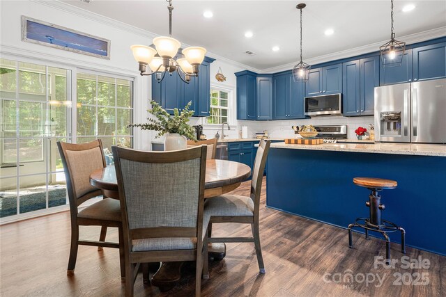 kitchen with stainless steel appliances, blue cabinetry, crown molding, tasteful backsplash, and dark wood-style floors