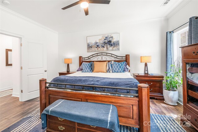 bedroom featuring ornamental molding, dark wood-style floors, a ceiling fan, and baseboards