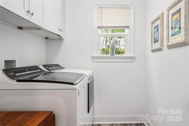 laundry area featuring cabinet space, washer and dryer, baseboards, and wood finished floors
