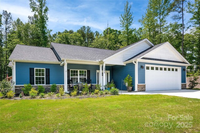ranch-style house with stone siding, an attached garage, a front yard, and concrete driveway