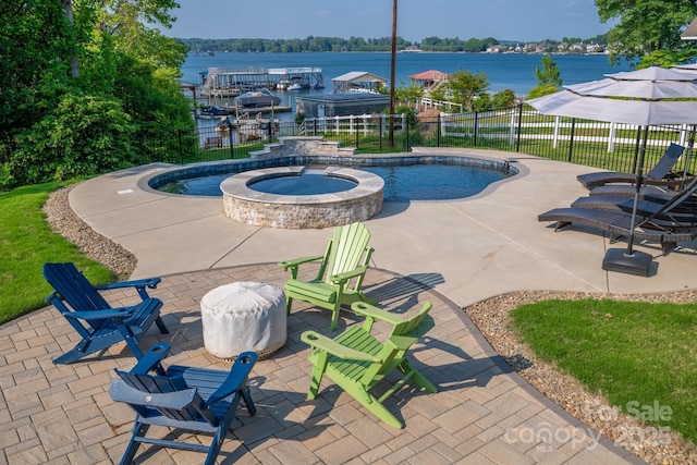 view of swimming pool featuring a patio area, a water view, and fence