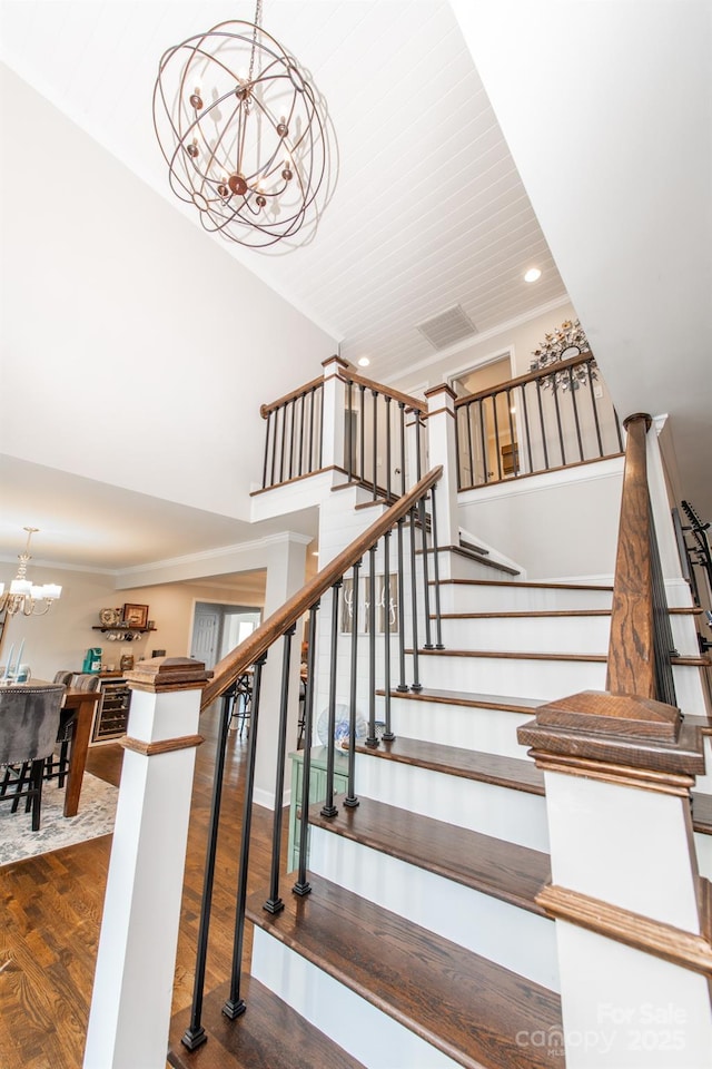 stairway featuring an inviting chandelier, wood finished floors, and recessed lighting