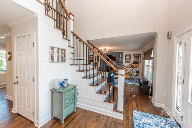 stairs featuring crown molding, baseboards, a healthy amount of sunlight, and wood finished floors