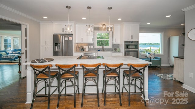 kitchen with dark wood finished floors, a sink, white cabinetry, tasteful backsplash, and appliances with stainless steel finishes