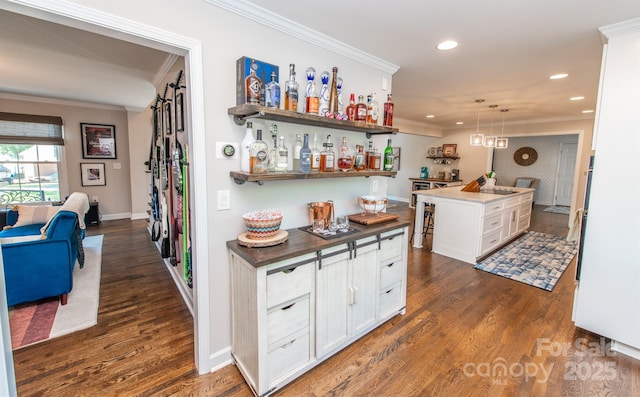 bar featuring indoor bar, ornamental molding, dark wood finished floors, and recessed lighting