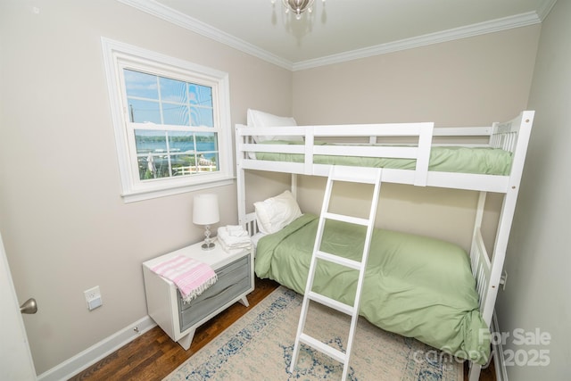 bedroom featuring ornamental molding, baseboards, and wood finished floors