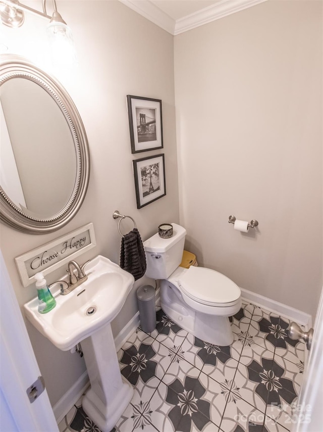bathroom featuring tile patterned floors, crown molding, toilet, and baseboards