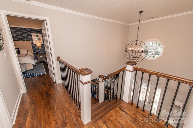 staircase with a chandelier, crown molding, plenty of natural light, and wood finished floors