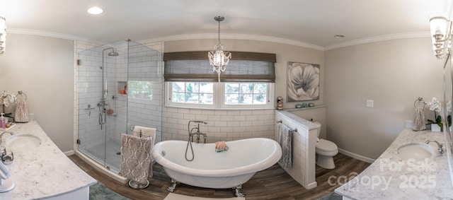 full bathroom featuring a sink, a shower stall, a soaking tub, double vanity, and wood finished floors