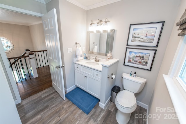 bathroom featuring toilet, baseboards, crown molding, and wood finished floors