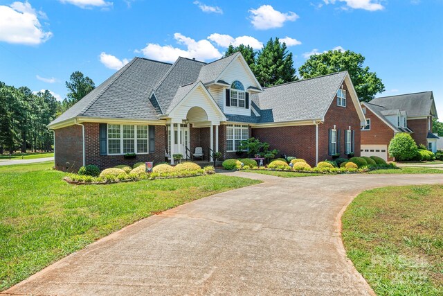 14340 Kendalton Meadow Dr, Mint Hill, NC 28227 - view of front facade featuring brick siding, a front yard, concrete driveway, and roof with shingles
