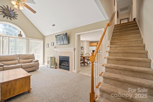 14340 Kendalton Meadow Dr, Mint Hill, NC 28227 - living area with high vaulted ceiling, stairway, ceiling fan, carpet, and a tiled fireplace