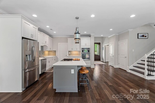 112 Nautilus Ct, Troutman, NC 28166 - kitchen featuring stainless steel appliances, light countertops, baseboards, a kitchen bar, and decorative backsplash