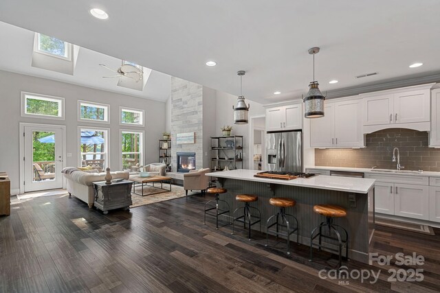 112 Nautilus Ct, Troutman, NC 28166 - kitchen featuring stainless steel appliances, a sink, a high ceiling, open floor plan, and healthy amount of natural light