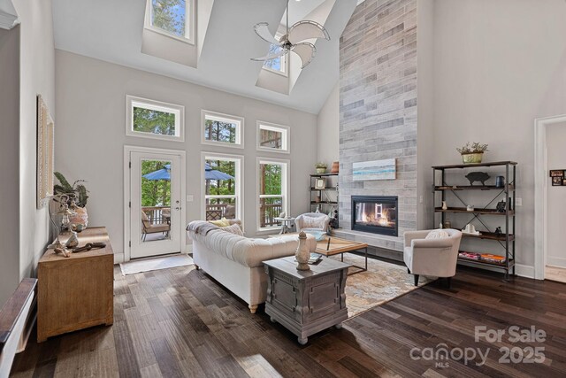 112 Nautilus Ct, Troutman, NC 28166 - living area with high vaulted ceiling, dark wood-type flooring, a fireplace, a ceiling fan, and a skylight