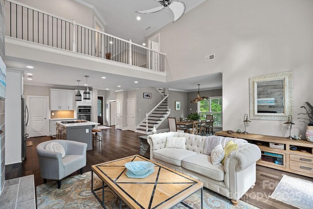 112 Nautilus Ct, Troutman, NC 28166 - living area with stairway, a high ceiling, ornamental molding, recessed lighting, and dark wood-style flooring