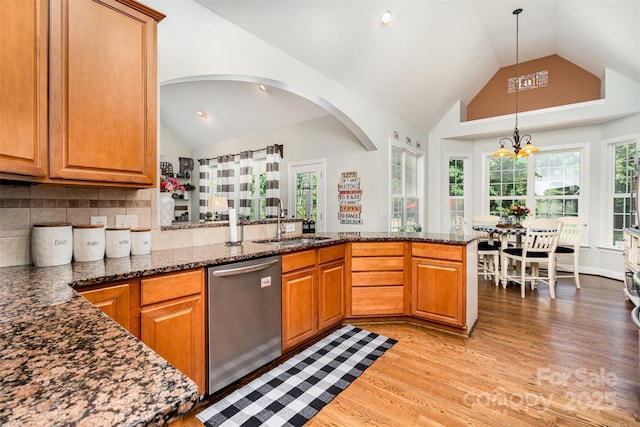 6603 Havencrest Dr, Denver, NC 28037 - kitchen with dishwasher, a sink, light wood-style flooring, a peninsula, and dark stone counters
