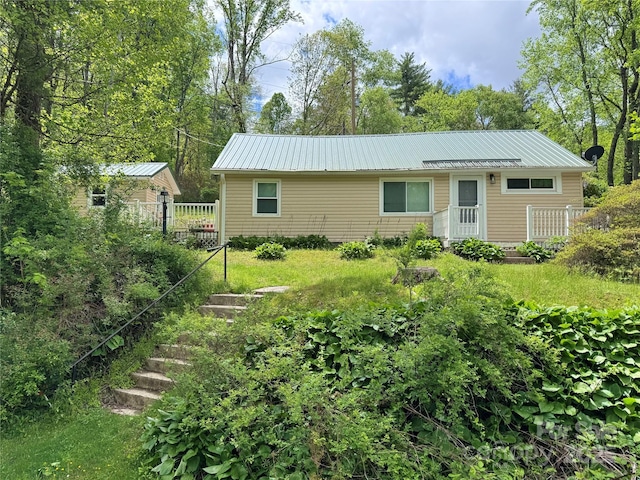 back of property with metal roof and stairway