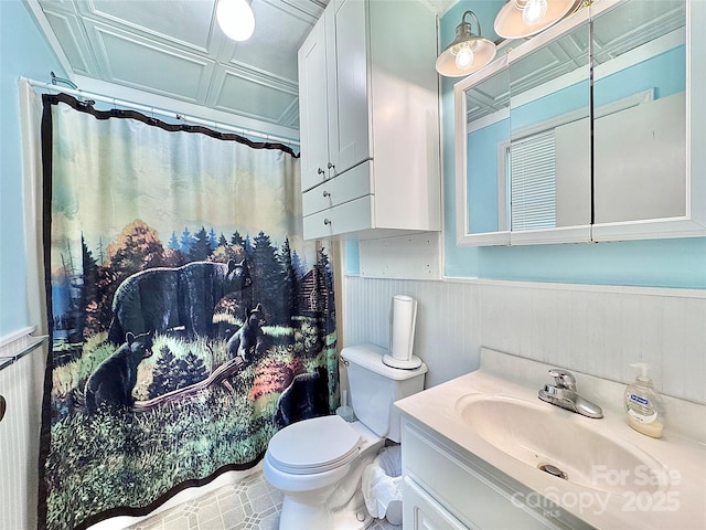 bathroom featuring vanity, toilet, a shower with curtain, and a wainscoted wall