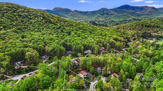 drone / aerial view featuring a wooded view and a mountain view