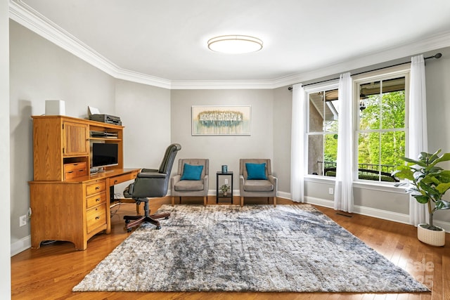 office space with baseboards, ornamental molding, and light wood-type flooring