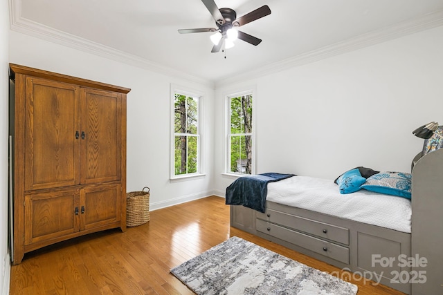 bedroom with crown molding, baseboards, a ceiling fan, and light wood finished floors