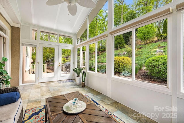 unfurnished sunroom featuring a ceiling fan, plenty of natural light, and french doors