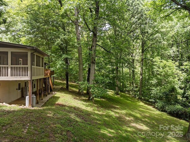 1128 Forest St, Mars Hill, NC 28754 - view of green lawn featuring a sunroom, a patio area, a wooded view, and a deck