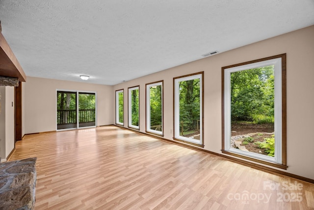 1128 Forest St, Mars Hill, NC 28754 - unfurnished living room featuring light wood-type flooring, a textured ceiling, and baseboards