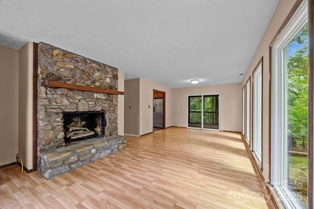 1128 Forest St, Mars Hill, NC 28754 - unfurnished living room with light wood-style flooring, a fireplace, baseboards, and a textured ceiling