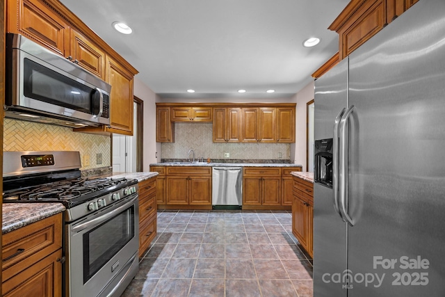1128 Forest St, Mars Hill, NC 28754 - kitchen with appliances with stainless steel finishes, tasteful backsplash, brown cabinets, a sink, and recessed lighting