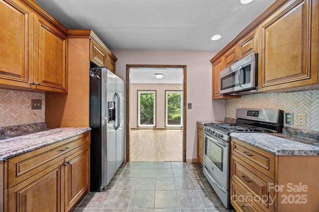 1128 Forest St, Mars Hill, NC 28754 - kitchen featuring stainless steel appliances, brown cabinets, tasteful backsplash, light stone counters, and recessed lighting