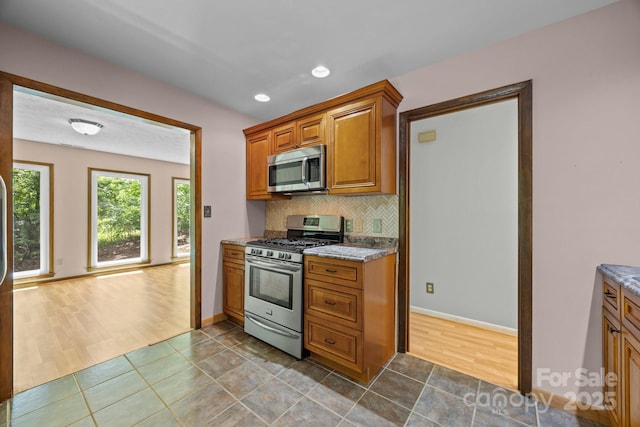 1128 Forest St, Mars Hill, NC 28754 - kitchen with appliances with stainless steel finishes, brown cabinets, tasteful backsplash, light stone counters, and recessed lighting